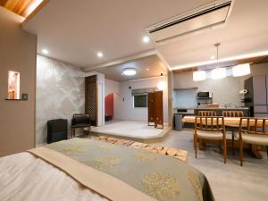 Zimmer mit einem großen Bett und einem Esszimmer in der Unterkunft SWEET VILLA TAKASAMA2 - Vacation STAY 11608v in Fujiyoshida
