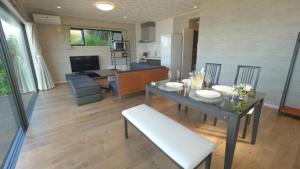 a dining room with a table and chairs and a kitchen at Padel Okinawa Villa - Vacation STAY 32469v in Uruma