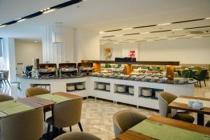 a restaurant with tables and a counter with food at Sabırlar City Suites Hotel in Trabzon