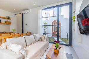 a living room with a white couch and a large window at Byjexa Villa by Betterplace in Uluwatu