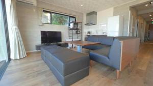 a living room with a table and a blue couch at Padel Okinawa Villa - Vacation STAY 32469v in Uruma