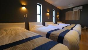 a group of four beds in a room at Padel Okinawa Villa - Vacation STAY 32469v in Uruma
