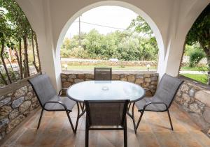 a table and chairs on a patio with two arches at Erietta Studios & Apartments by Kika Residences in Stoupa