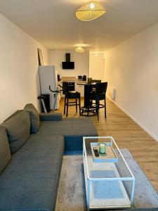 a living room with a couch and a table at Appartement chaleureux in Tain-lʼHermitage +4 photos