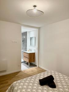 a bedroom with a bed and a bathroom with a sink at Appartement chaleureux in Tain-lʼHermitage