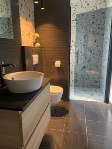 a bathroom with a sink and a toilet and a shower at Room with Balcony and Sea View in Zadar