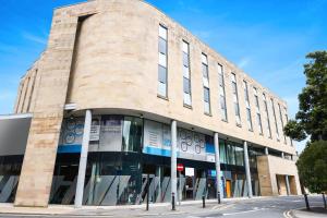 a large brick building on a city street at GO2 Lancaster Centre Hotel by OYO in Lancaster