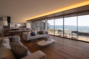 ein Wohnzimmer mit Couch und Tisch und eine Küche in der Unterkunft GIFTHOUSE Tateyama Nagokaigan - Vacation STAY 16008 in Tateyama