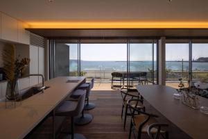 ein Restaurant mit Tischen und Stühlen und Blick auf das Meer in der Unterkunft GIFTHOUSE Tateyama Nagokaigan - Vacation STAY 16008 in Tateyama