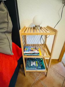 a small wooden table with a lamp and books on it at Forest Nest Huchenfeld in Pforzheim