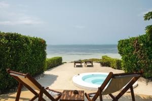 eine Terrasse mit Pool und zwei Stühlen und dem Meer in der Unterkunft Zanbluu Beach Hotel in Kiwengwa