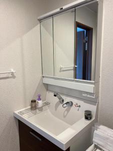 a bathroom with a white sink and a mirror at Populasunupuri - Vacation STAY 62945v in Otaru +18 photos