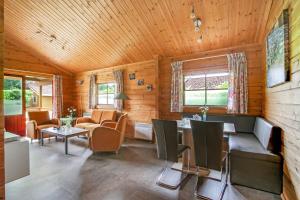 a living room filled with furniture and a wooden ceiling at Vakantiepark 't Hooge Holt in Gramsbergen