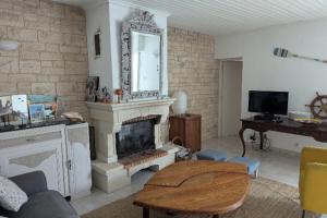 a living room with a fireplace and a mirror at House ideal for families 10 min from the beaches in Le Bois-Plage-en-Ré
