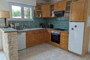 a kitchen with wooden cabinets and a white refrigerator at House ideal for families 10 min from the beaches in Le Bois-Plage-en-Ré +11 photos