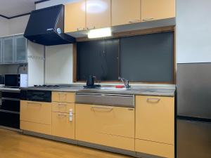 a kitchen with yellow cabinets and a sink at Hibisha - Vacation STAY 66595v in Amakusa +22 photos