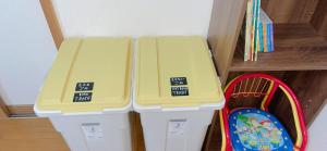 two trash cans with yellow covers sitting next to a shelf at Hibisha - Vacation STAY 66595v in Amakusa