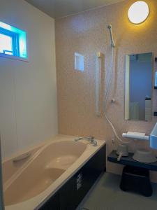 a bathroom with a tub and a shower and a sink at TSK Nanjyo - Vacation STAY 70147v in Sashiki
