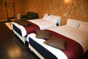 una habitación de hotel con 3 camas y una silla en Sasebo - Cottage - Vacation STAY 71282v, en Sasebo