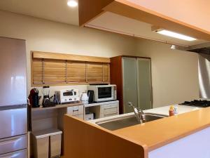 a kitchen with a sink and a microwave at Rental Villa Karuizawa Honors Hill - Vacation STAY 71491v in Oiwake +2 photos