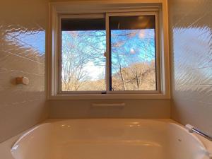 a bath tub in a bathroom with a window at Rental Villa Karuizawa Honors Hill - Vacation STAY 71491v in Oiwake