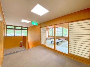an empty room with wooden walls and windows at Succeeding Gorge Onsen Hall - Vacation STAY 74512v in Inuma