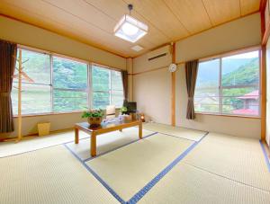 an empty room with a table and some windows at Succeeding Gorge Onsen Hall - Vacation STAY 74512v in Inuma