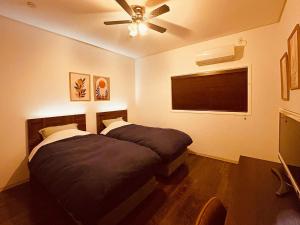a bedroom with a bed and a ceiling fan at Second floor - Vacation STAY 16317 in Ginowan
