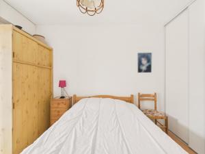 une chambre avec un lit et une armoire en bois dans l'établissement 400m de la Grande plage, 2 adultes 2 enfants, à Saint-Gilles-Croix-de-Vie