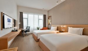 a hotel room with two beds and a desk at Holiday Inn Express Chengdu Huanhuaxi by IHG-Near Jinsha Site Musem,Near Wuhou Temple Museum,Welcome drinks,Free gym,Free self-service laundry in Chengdu +52 photos