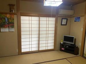 a room with a sliding door with a television at HANAMIDORI Sugata Hotaru no Sato - Vacation STAY 16201 in Gujo +14 photos