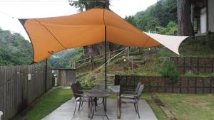 a table and chairs with an umbrella on a patio at Ashigarakami-gun - Camp - Vacation STAY 84740v in Hokizawa