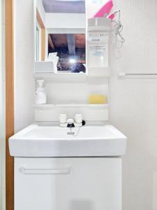 a bathroom with a white sink and a mirror at Ichishuku Ikkei Issei-Chiba Prefecture Yotsukaido - Vacation STAY 16240 in Yotsukaidō