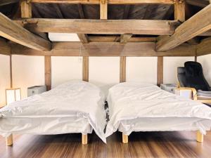 two beds in a room with wooden ceilings at Ichishuku Ikkei Issei-Chiba Prefecture Yotsukaido - Vacation STAY 16240 in Yotsukaidō
