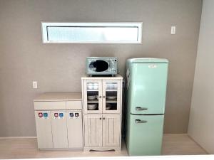 a kitchen with a refrigerator and a microwave at Karatsu seaside house - Vacation STAY 94789v in Karatsu