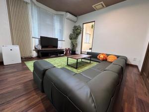 a living room with a leather couch and a table at Hakodate Kasumi - Vacation STAY 90771v in Hakodate