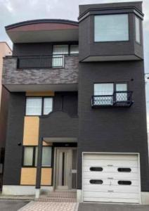 a large black house with a white garage at Hakodate Kasumi - Vacation STAY 90771v in Hakodate