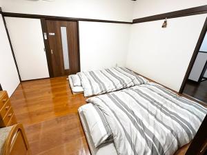 two unmade beds in a room with wood floors at Tanabe no Yado Ataigawa - Vacation STAY 10883v in Tanabe +19 photos