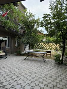 una panca da picnic seduta su un patio in mattoni di Charming Private House Pekini av a Tbilisi City