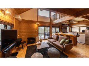 a living room with a couch and a fireplace at Kurokawa Mori No Kiki - Vacation STAY 14693v in Aso