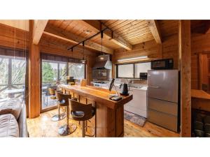 a kitchen with a table and a refrigerator at Kurokawa Mori No Kiki - Vacation STAY 14693v in Aso +34 photos