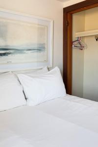 a bed with white sheets and a painting on the wall at Lucky 7 at Lakeshore Resort in Traverse City