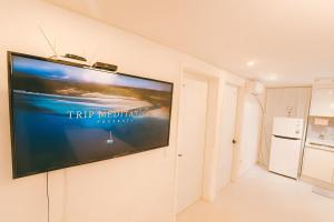 a flat screen tv hanging on a wall at Queen Bed 5 #10 people # Airport Railway Station # Triple Station # Hong dae # seoul #3room # DMC # bnb in Seoul +19 photos
