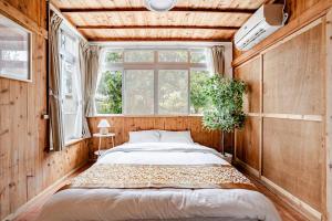 ein Schlafzimmer mit einem Bett und einem Fenster in der Unterkunft Kayo BASE in Nago + 22 Fotos