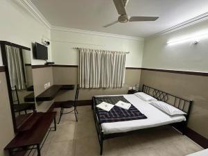 a bedroom with a bed and a table and chairs at Mayur Paradise in Bangalore