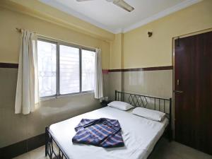 a bedroom with a bed with a blanket on it at Mayur Paradise in Bangalore