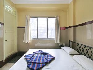 a bed with a blanket on it in a bedroom at Mayur Paradise in Bangalore