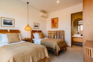 una camera d'albergo con due letti e un bagno di Sabiha Villas Nusa Lembongan a Nusa Lembongan