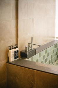 a row of bottles sitting on a counter next to a sink at 涠洲岛隐拙山与澜海景酒店 in Weizhouxu