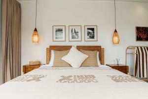 una camera da letto con un grande letto bianco con cuscini di Sabiha Villas Nusa Lembongan a Nusa Lembongan Altre 37 foto